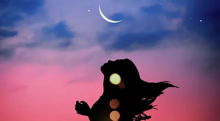 Silhouette of a person against a pink and blue dusk sky with a crescent moon